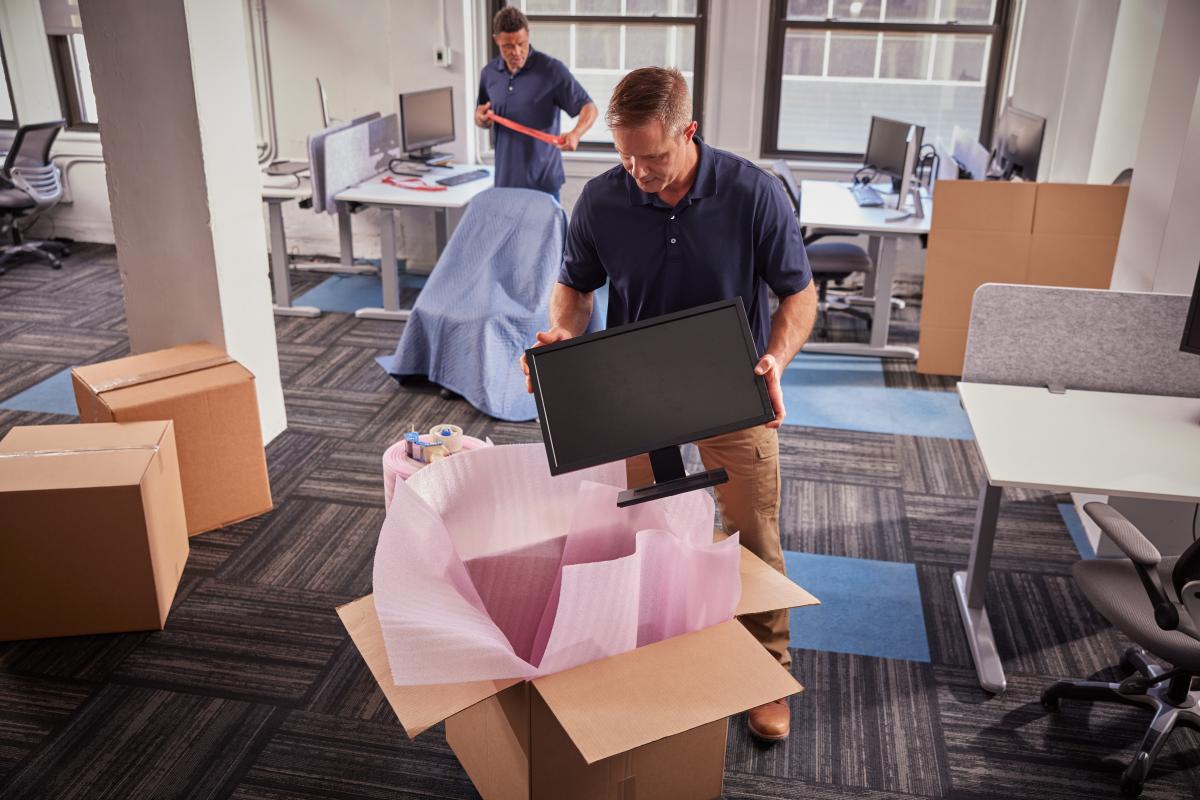 Navis team packing computer systems and furniture for shipping.